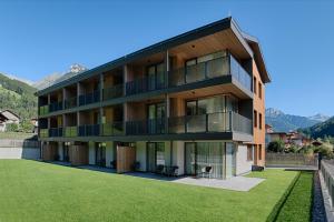 un immeuble d'appartements avec une pelouse devant lui dans l'établissement Luxegg - Mountain Lodge, à Lutago