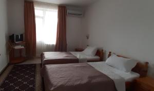 a hotel room with two beds and a window at MOTEL INTERNATIONAL in Berkovitsa