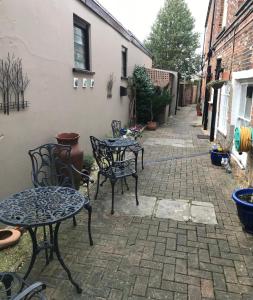 patio ze stołami i krzesłami na chodniku w obiekcie Newport Quay w mieście Newport