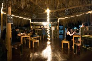 un gruppo di persone sedute ai tavoli di un ristorante di Crazy Bears Hostel a Moalboal