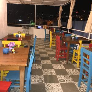 une salle à manger avec des tables et des chaises colorées dans l'établissement Halikarnas Pansiyon, à Bodrum City