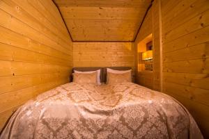 ein Schlafzimmer mit einem Bett in einem Holzzimmer in der Unterkunft Chalet Obertraun in Obertraun