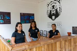 un grupo de chicas de pie en el mostrador de un bar en Crazy Bears Hostel, en Moalboal