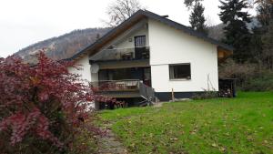 uma casa branca com uma varanda e um quintal em RELAX in der Natur 2 Zimmer Apartment - im Grünen - Ruhelage em Kennelbach
