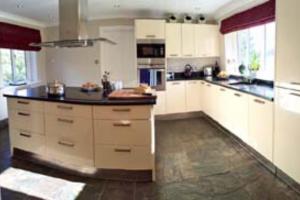 a kitchen with white cabinets and a large island at The Bridge House, Dunbar in Dunbar