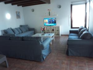 a living room with two couches and a tv at Villa Elegante in Cala Morell