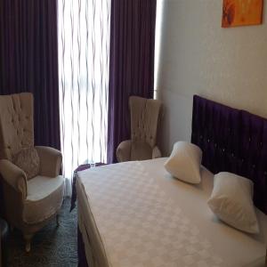 a hotel room with a bed and two chairs at The Tuyap Rainbow Suites in Beylikduzu