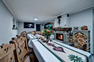 a long dining room with a long table and a fireplace at Willa Topór in Witów