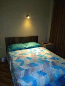 a bedroom with a bed with a colorful quilt on it at D´ Barrig in Trujillo