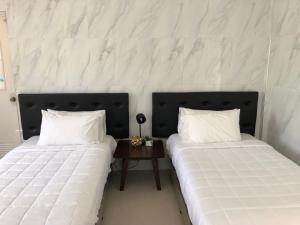 two beds sitting next to each other in a room at Arriyus Apartelle in Maya