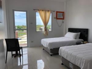 a hotel room with two beds and a window at Arriyus Apartelle in Maya