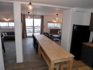 a living room with a wooden table and chairs at Appart POUR 18 SUPERBE VUE A COTE DU TELESIEGE in Les Deux Alpes