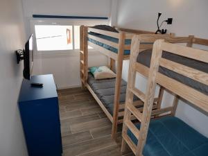 a small room with two bunk beds and a desk at Appart POUR 18 SUPERBE VUE A COTE DU TELESIEGE in Les Deux Alpes