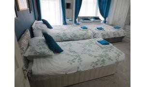 three beds in a room with blue walls and windows at The Salendine in Blackpool