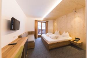 a hotel room with a bed and a tv at Barbarahof in Werfenweng