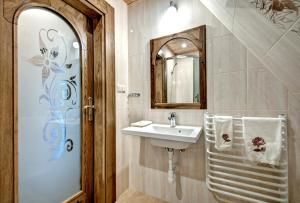 a bathroom with a sink and a mirror at Willa Topór in Witów