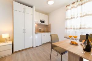a kitchen and dining room with a table and chairs at Apartments & Room Libar in Split +21 photos