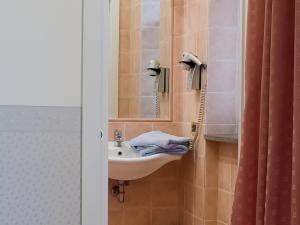 W łazience znajduje się umywalka i lustro. w obiekcie Hotel Louis II w Ciampino