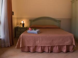 a bedroom with a bed with a pink blanket at Hotel Louis II in Ciampino