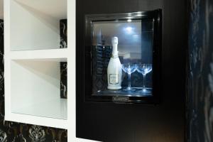 a bottle of wine in a cabinet with wine glasses at Hotel Blanc in Casoria
