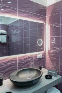 a bathroom with a round sink and purple walls at Hotel Blanc in Casoria +55 photos