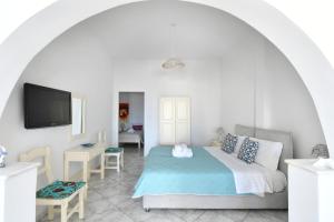 a bedroom with a bed and a flat screen tv at White Rooms Paros in Naousa