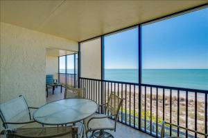 a balcony with a table and chairs and a view of the beach at Sea Oats 215 Apartment in Boca Grande