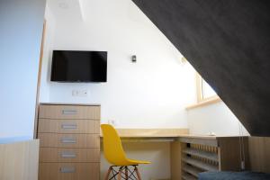 コパオニクにあるFamily Lux Apartmani Angella Konaciのベッドルーム(デスク、黄色い椅子付)