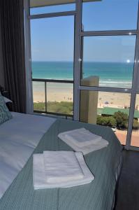 a bedroom with a bed with a view of the beach at 808 St Tropez in Cape Town