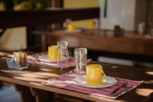 a wooden table with two plates and two cups on top at Aruá Observação de Vida Silvestre in Praia do Forte