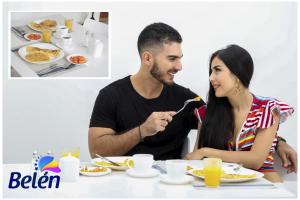 a man and a woman sitting at a table eating food at HOTEL BELEN-La Flora- Cali Valle del Cauca in Cali