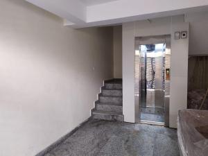 una stanza vuota con scale e porta a vetri di The Raveesh Lado - 1BHK Fully Furnished Apartment a Nuova Delhi