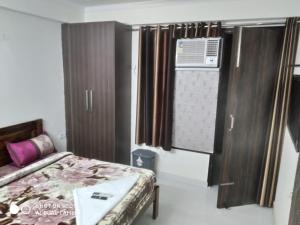 een kleine slaapkamer met een bed en airconditioning bij The Raveesh Lado - 1BHK Fully Furnished Apartment in New Delhi