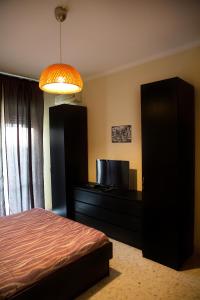 ナポリにあるOltremare Houseのベッドルーム1室(ベッド1台、ドレッサー、テレビ付)