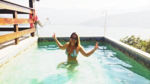 a woman standing in a swimming pool at Chalé da Clarissinha in Mangaratiba