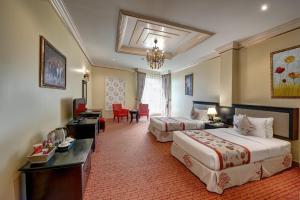 Habitación de hotel con 2 camas y escritorio en Sahara Beach Resort & Spa en Sharjah