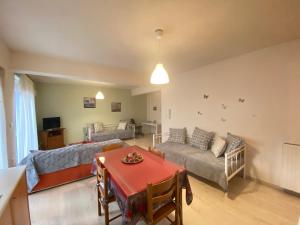 ein Wohnzimmer mit einem Sofa und einem Tisch in der Unterkunft Διαμέρισμα 65 τμ στην καρδιά της πόλης in Tripolis