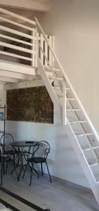 escalera blanca en una habitación con mesa y sillas en JANAS Country House en Castelsardo