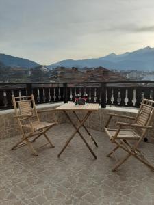 een houten tafel en twee stoelen op een dak bij Relax Dobrinishte in Dobrinishte