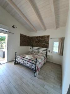 1 dormitorio con cama y pared de ladrillo en JANAS Country House en Castelsardo