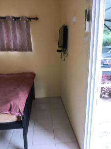 a small room with a bed and a tv at Sripech Home in Sangkhla Buri