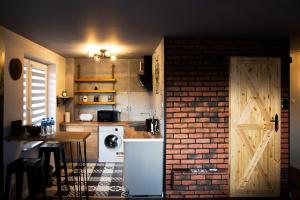 a kitchen with a washer and a brick wall at Apartament Wataha in Ustrzyki Dolne