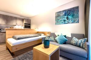 a small room with a bed and a couch at REINERS Quartier - relaxed living in Bruckberg