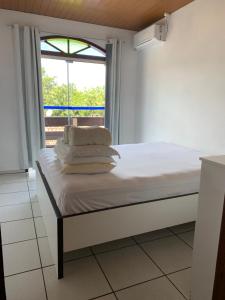 a bed with towels on it in a room with a window at Jucelio João Inácio in Governador Celso Ramos