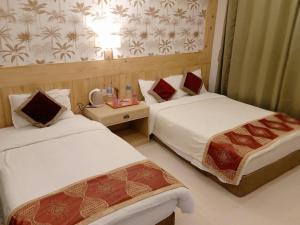 a hotel room with two beds and a table at Hotel Parkland in Sauraha