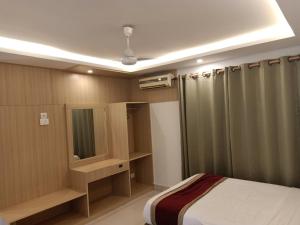 a bedroom with a bed and a mirror and a shower at Hotel Parkland in Sauraha