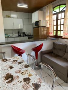 a kitchen with a table and a couch and a counter at Jucelio João Inácio in Governador Celso Ramos