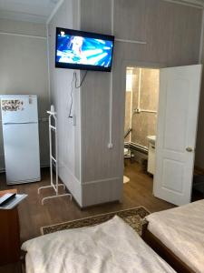 a room with a tv on the wall and a refrigerator at Гостевой дом Салонка in Chulkovo