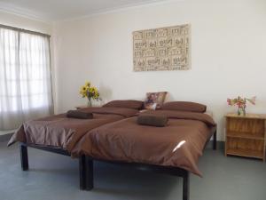 a bedroom with a large bed with brown sheets at Stop 'n Stay Otavi Rest Camp in Otavi