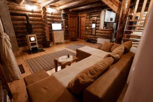 a living room with a large couch and a table at Zlatarske brvnare Zlatar Chalets in Nova Varoš